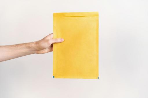 クッション封筒を差し出す手 配達,デリバリー,郵便の写真素材