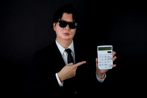 電卓を持つビジネスマン 電卓,ビジネスマン,スーツの写真素材