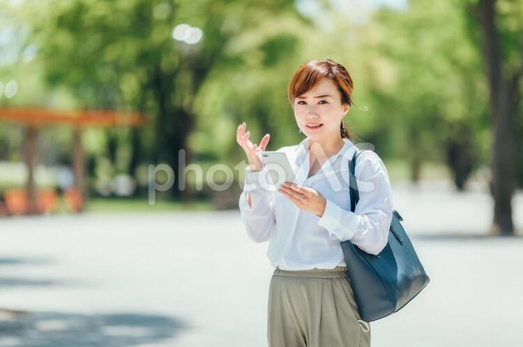 スマホを見て怒る女性 スマホ,悔しい,イライラの写真素材