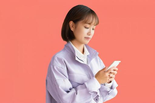 スマホを見る作業員女性 女性,作業服,現場の写真素材