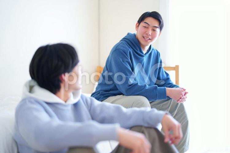 ベッドと床に座って話をしている2人の男性 引っ越し,一人暮らし,男性の写真素材