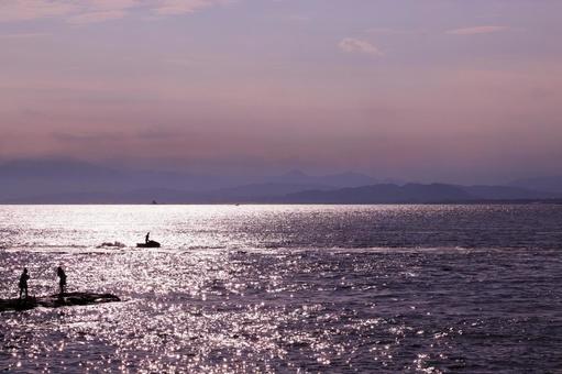 夕暮れ時を楽しむ海辺の景色 夕暮れ時を楽しむ海辺の景色 海,水平線,人物の写真素材