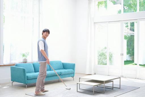 振り向きカメラ目線のラグを掃除中の男性 男性,振り向く,カーペットクリーナーの写真素材