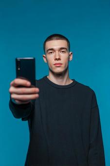 堂々とした表情でスマホを向けるティーン 堂々とした表情でスマホを向けるティーンの写真