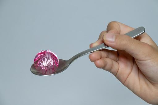 スプーン上のピンクのカットクリスタルと手 宝石,スプーン,手の写真素材