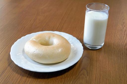 木のテーブルに置かれたベーグルと牛乳 ベーグル,パン,牛乳の写真素材
