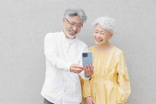 スマートフォンを使う笑顔のシニアカップル スマートフォンを使う笑顔のシニアカップル スマホ,スマートフォン,シニアの写真素材