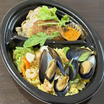 魚介のパエリアと豚肉香草パン粉焼きの弁当 魚介のパエリアと豚肉香草パン粉焼きの弁当の写真