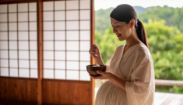 食事を美味しそうに食べる妊婦 食事を美味しそうに食べる妊婦の写真
