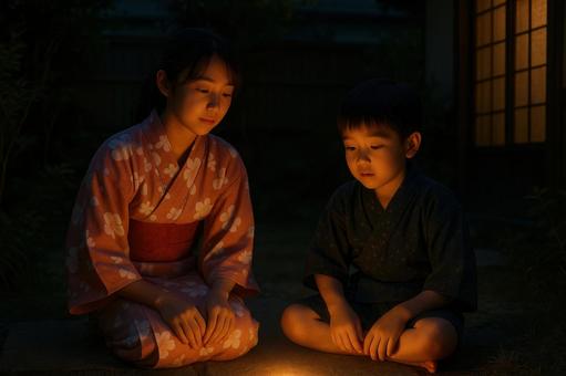 夜の庭で光を見る姉弟 夜の庭で光を見る姉弟の写真