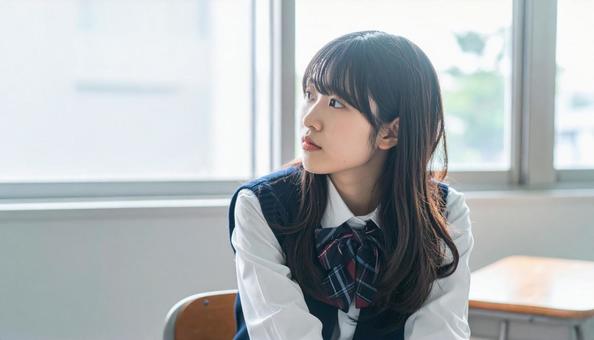学校の教室で窓の外を眺める女子高校生横顔 学校の教室で窓の外を眺める女子高校生横顔の写真