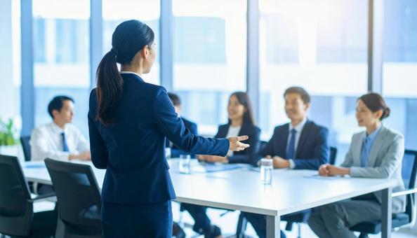 会議で発言をする女性社員の後ろ姿 会議で発言をする女性社員の後ろ姿の写真