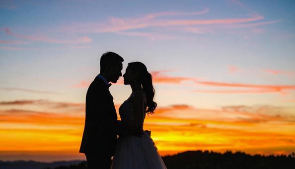 夕日の草原の中の花嫁と花婿 ウエディング 夕日の草原の中の花嫁と花婿 ウエディングの写真