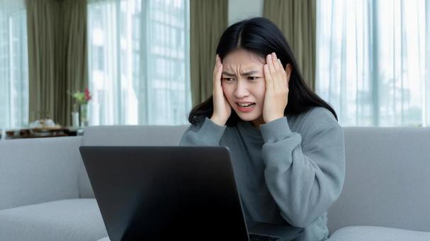 PCの前で頭を抱える女性 02 PCの前で頭を抱える女性 02の写真