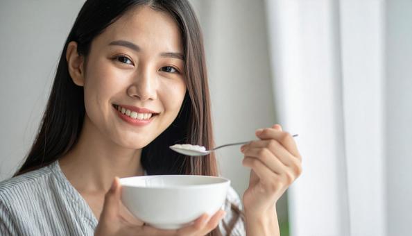 おかゆをすくう女性 おかゆをすくう女性の写真