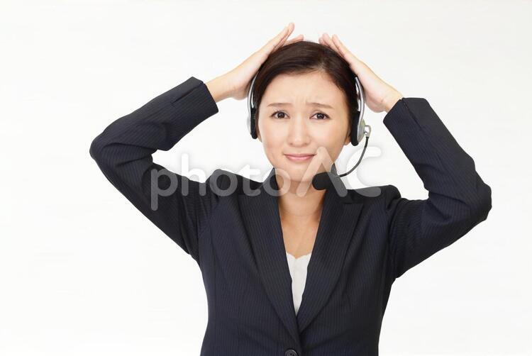 頭を抱えるオペレーター 女性,女,オペレーターの写真素材