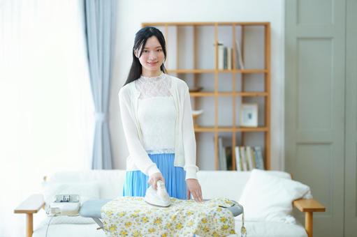 カメラ目線でアイロンを持つ女性 女性,アイロン,アイロン台の写真素材