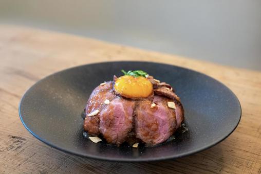 ローストビーフ丼と卵黄の盛り付け ローストビーフ丼と卵黄の盛り付けの写真
