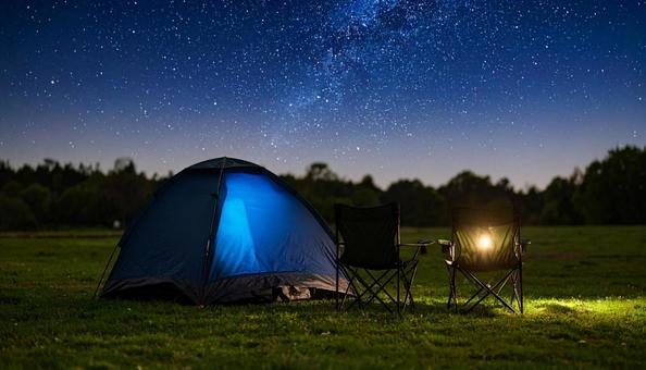 夜の星空の下の焚き火とテントキャンプ 夜の星空の下の焚き火とテントキャンプの写真