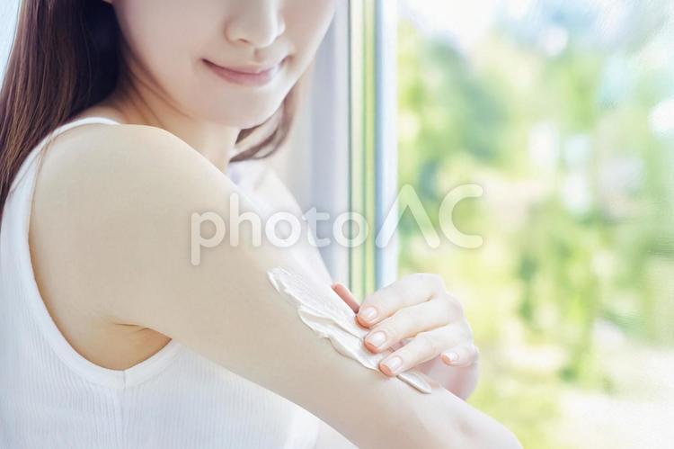 腕にクリームを塗る女性 日焼け止め,クリーム,紫外線の写真素材