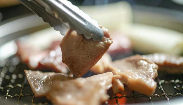 炭火焼肉 トングでつまむ 炭火焼肉 トングでつまむの写真