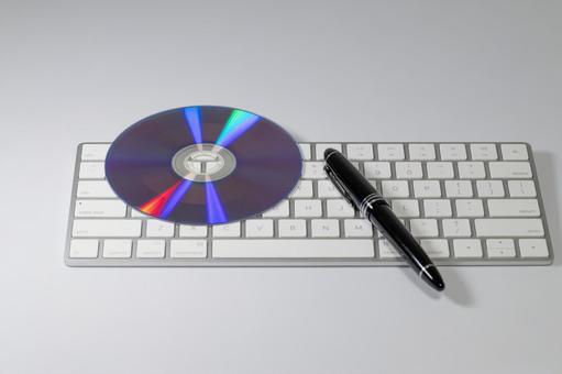 白いキーボード上のCDと万年筆 cd,キーボード,万年筆の写真素材