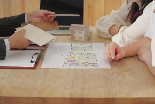 営業マンと家づくりの相談をする若い夫婦 営業マンと家づくりの相談をする若い夫婦 住宅,家,新築の写真素材