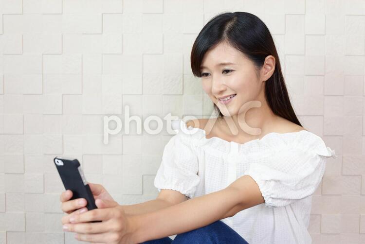 スマートフォンを持つ笑顔の女性 女性,スマートフォン,女の写真素材