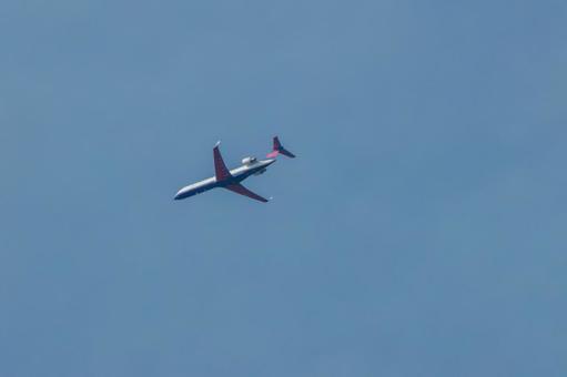 晴天の空を高く飛ぶジェット旅客機 晴天の空を高く飛ぶジェット旅客機の写真