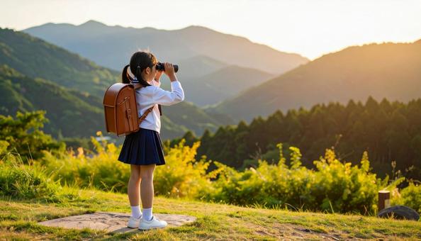 双眼鏡で遠くを眺める小学生の女の子 双眼鏡で遠くを眺める小学生の女の子の写真