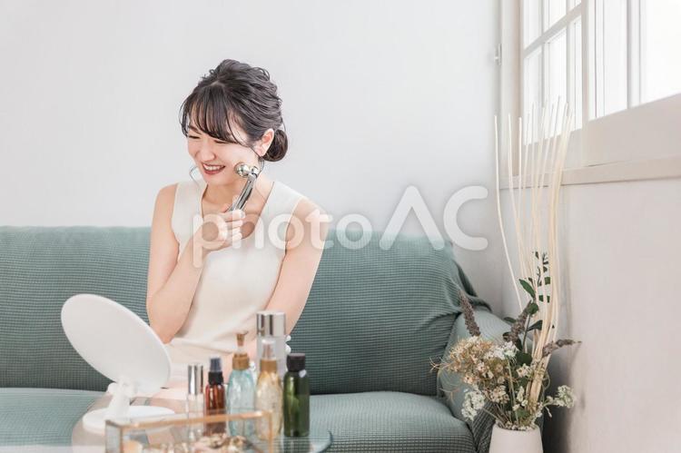 美顔器でマッサージする若いアジア人女性 美顔器,マッサージ,美顔ローラーの写真素材