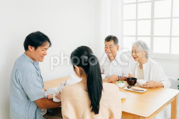 里帰り出産・食事をする老夫婦と若い夫婦 出産祝い,里帰り出産,孫の写真素材