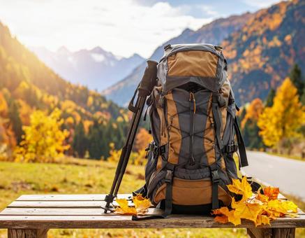 木のベンチに置かれた登山リュック 木のベンチに置かれた登山リュックの写真