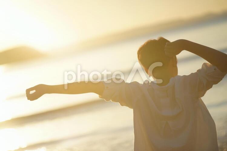 夕日と海とボーイッシュな女の子 女性,笑顔,お出かけの写真素材