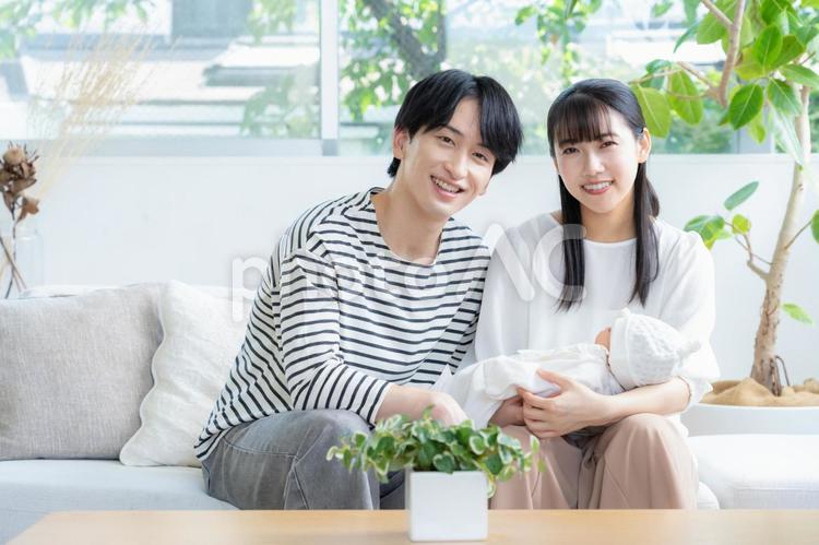 リビングで赤ちゃんを抱く若い家族 家族,親子,赤ちゃんの写真素材