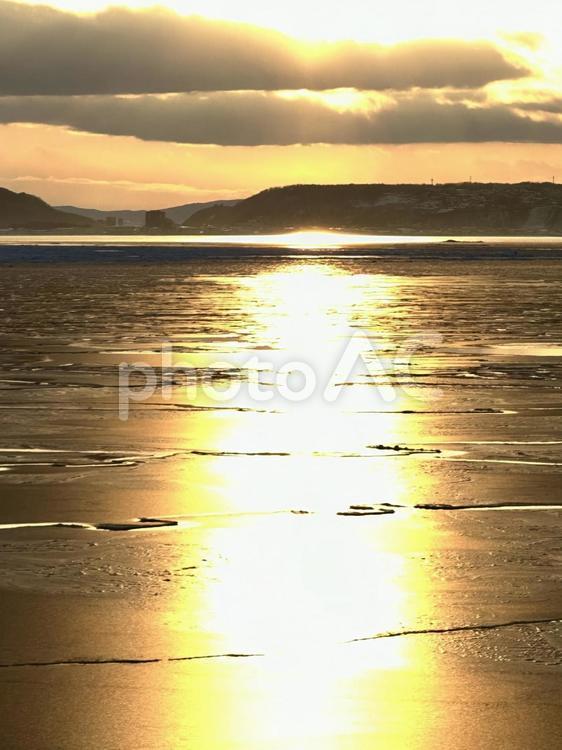 流氷の海に映る夕日 冬,夕日,海の写真素材