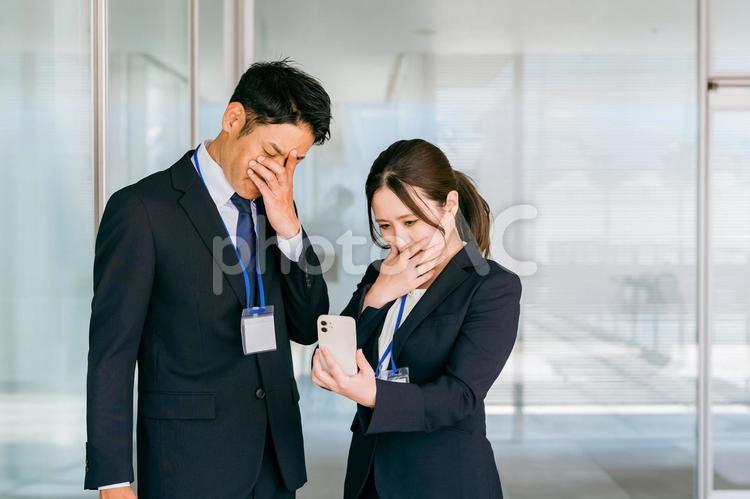 スマホを見て泣くビジネスマン（トラブル） トラブル,悲報,スマホの写真素材