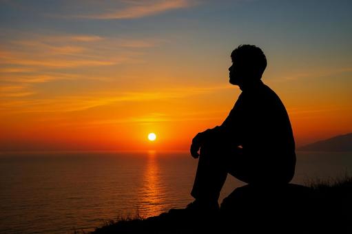 夕日を眺めるシルエット人物 夕日を眺めるシルエット人物の写真
