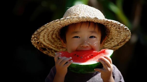 スイカを齧る麦わら帽子の男の子 スイカを齧る麦わら帽子の男の子の写真