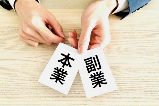 本業と副業のカードを持つビジネスマンの手 副業,本業,稼ぐの写真素材
