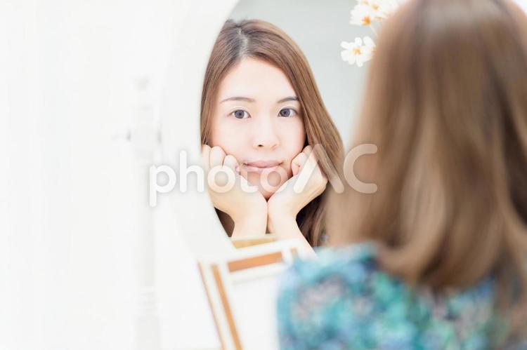 鏡の前で考え事をする若い女性 女性,鏡,ドレッサーの写真素材