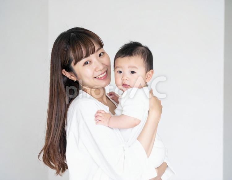 赤ちゃんを抱いて微笑んでいる若いお母さん 赤ちゃん,赤ん坊,ベビーの写真素材