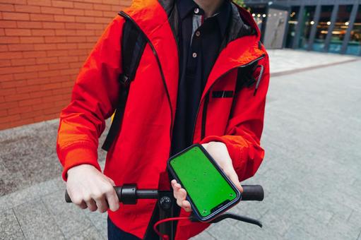 街なかでスマートフォンの画面を見せるフ配達員男性の手元 配達,フードデリバリー,デリバリーの写真素材