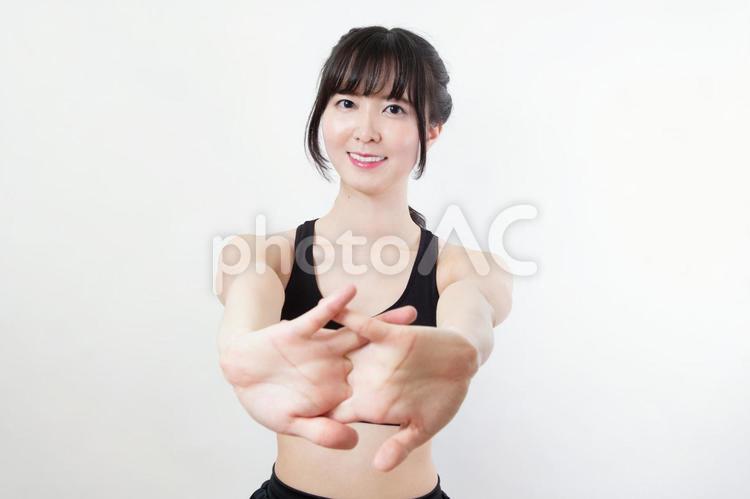腕伸ばしのストレッチをする若い女性 筋トレ,エクササイズ,トレーニングの写真素材