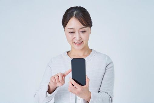 スマートフォンを操作する女性 スマートフォンを操作する女性 スマートフォン,スマホ,女性の写真素材