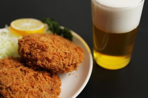 ビールとメンチカツの食事 ビールとメンチカツの食事の写真