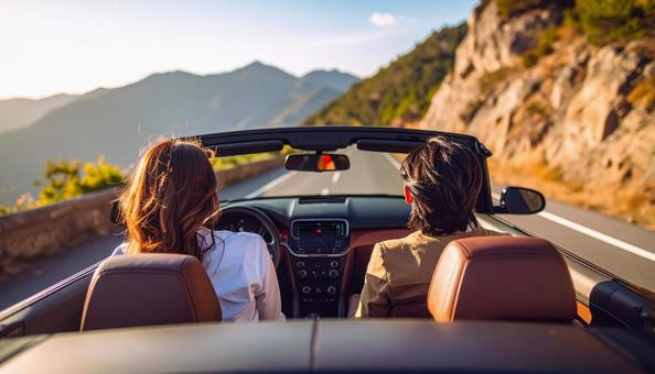 オープンカーに乗ってデートするカップルの写真