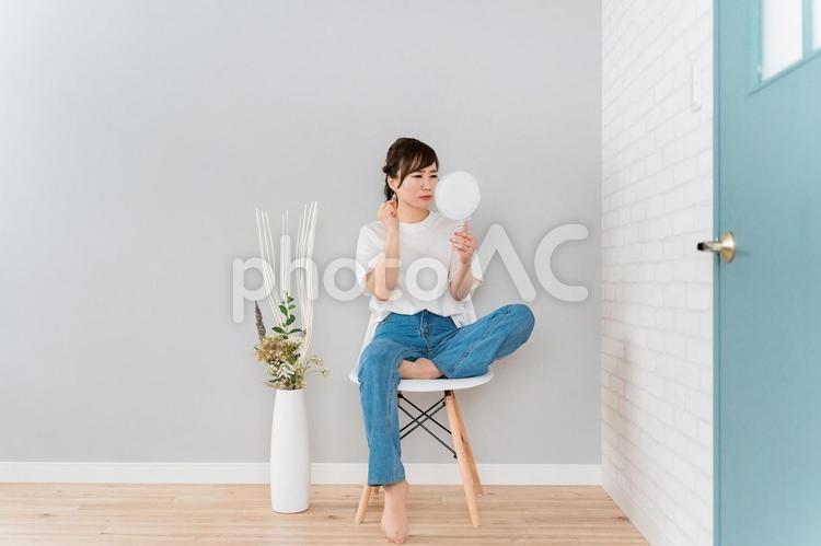 鏡を見てピアスをチェックするアジア人女性 ピアス,耳,女性の写真素材