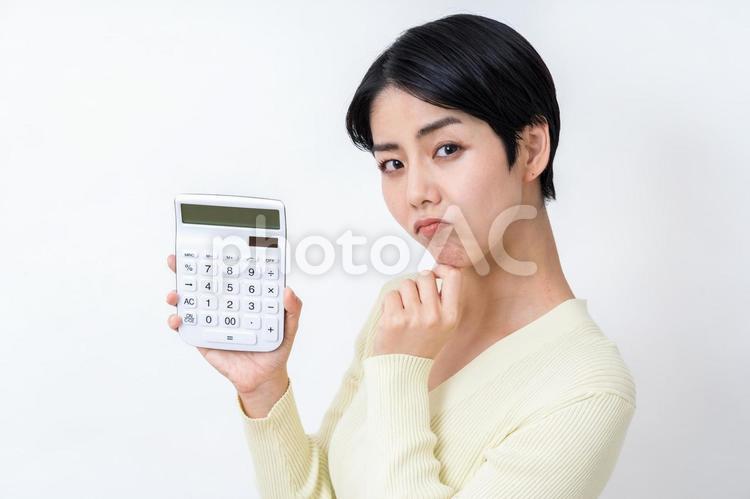 電卓を持って悩む主婦。 主婦,電卓,家計の写真素材