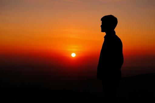 夕日を見つめるシルエット 夕日を見つめるシルエットの写真